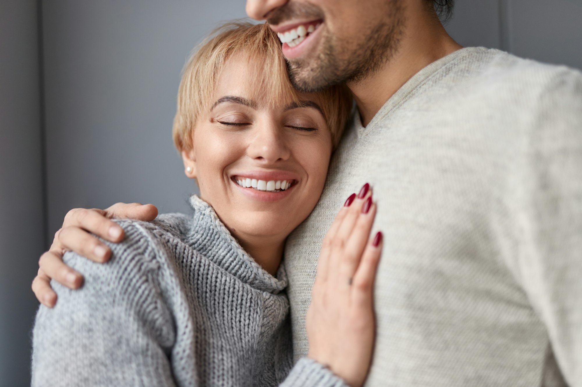 Smiling woman leaning on chest of husband
